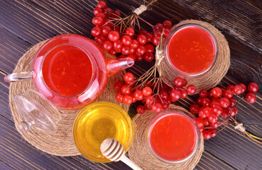 Medicinal tea or fruit drink made from viburnum berries with honey on a dark wooden background. Flat lay.
