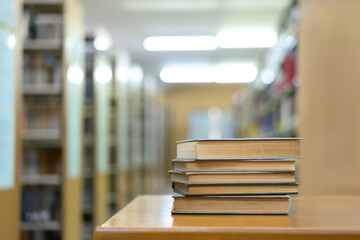 Book stack in the library and blurred bookshelf background for education