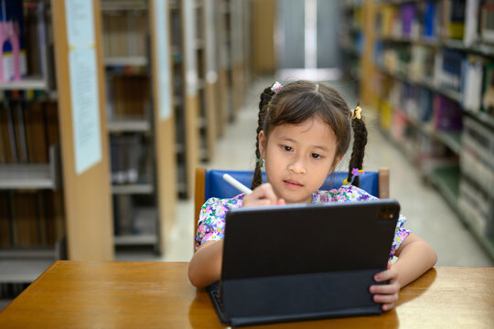 Photo set Asian little girl learning on tablet in library, smiling happiness