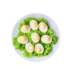 hard boiled chicken eggs and mayonnaise in a ceramic plate isolated on a white background, top view.