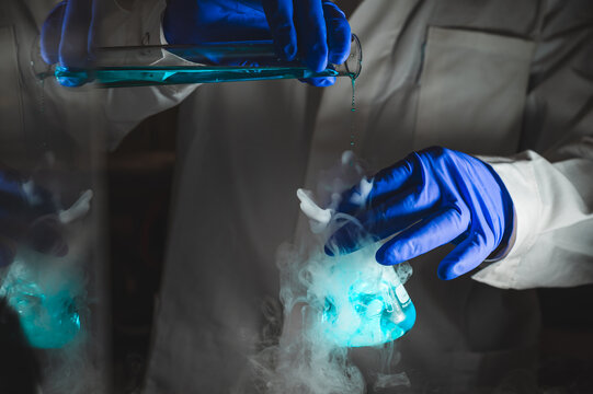 Smoky experiments with blue colour solution.  Scientist working on chemical reaction