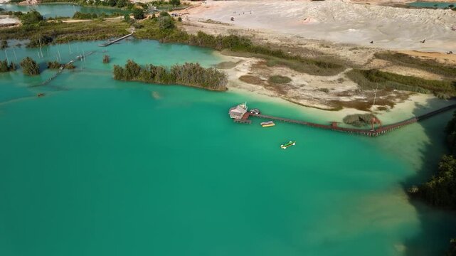 bintan islands blue lagoon also known as danau biru features striking turquoise waters surrounded by white sand hills creating a stunning contrast and serene tropical atmosphere