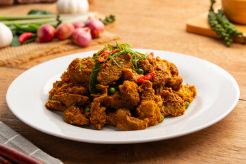 Stir Fried Beef with Yellow Curry Paste.Thai Southern Style Spicy sliced beef meat in white plate.(Kua-Kling)