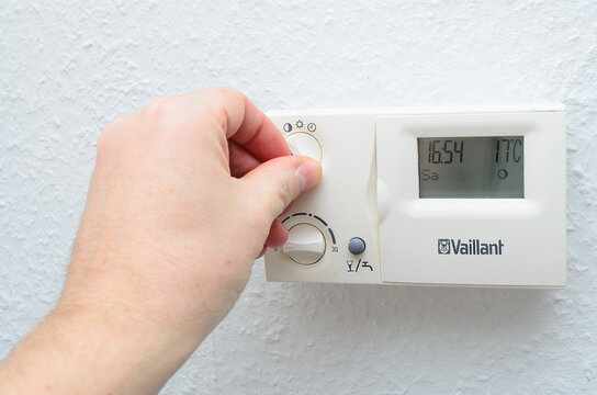 Iserlohn Germany October 26 2025 human hand adjusting Vaillant boiler thermostat in home environment