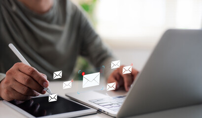 A Businessman working on laptop, tablets open email with triangle caution warning sign for notification error, maintenance concept, network security, computer virus detected, personal data protection.