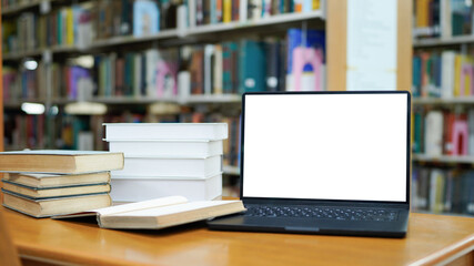 Blur library interior background for your design, desk with books and laptop