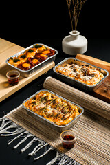 flavor dimsum — spicy red sauce, sesame topping, and cheesy melt — served in aluminum trays. Elegant Asian fusion food photography with modern presentation.