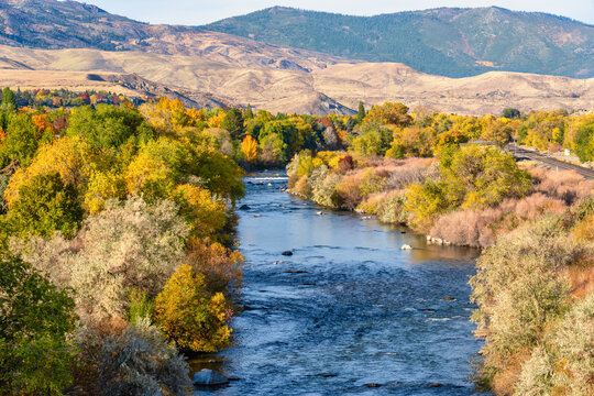 High angle view of the Truckee River west of Reno Nevada during Autumn with colorful vibrant yellow red and green tree leaves and deep blue water in the flowing river.