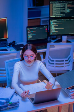Asian female smart programmer works late night office coding deep learning AI models, training neural networks with intense concentration and focus, dedicating overtime hours alone to machine learning