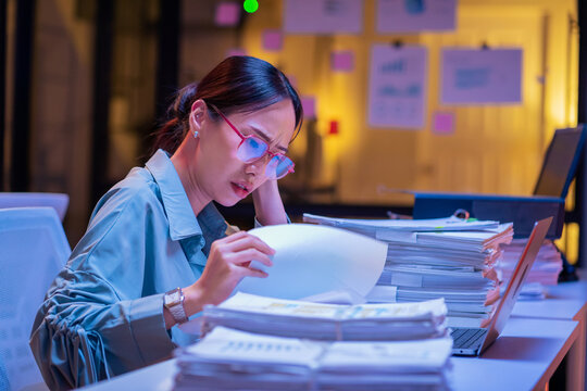 Asian female smart programmer works late night office coding deep learning AI models, training neural networks with intense concentration and focus, dedicating overtime hours alone to machine learning