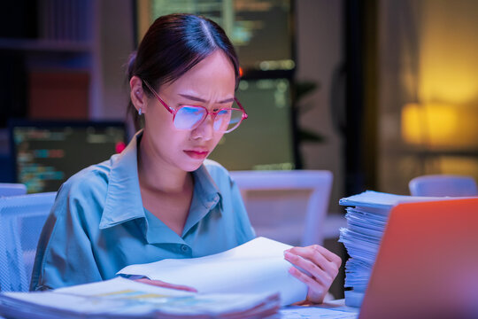 Asian female smart programmer works late night office coding deep learning AI models, training neural networks with intense concentration and focus, dedicating overtime hours alone to machine learning