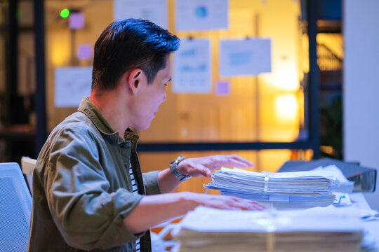 Asian programmer male works hard and alone in his office at night, intensely concentrating and focusing on coding AI deep learning and AI train models, embodying dedication to digital innovation