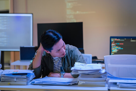 Asian programmer works late night office coding deep learning AI models, training neural networks with intense concentration and focus, dedicating overtime hours alone to machine learning development 