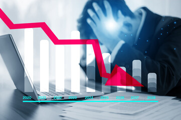 Investor stressed after stock market downturn with laptop and falling graph illustrating business...