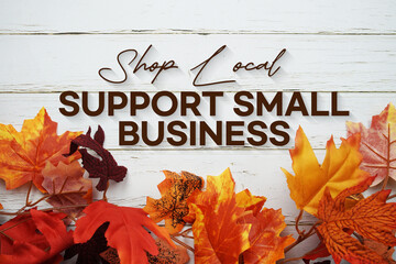 Support Small Business text with maple leaf decoration on wooden background