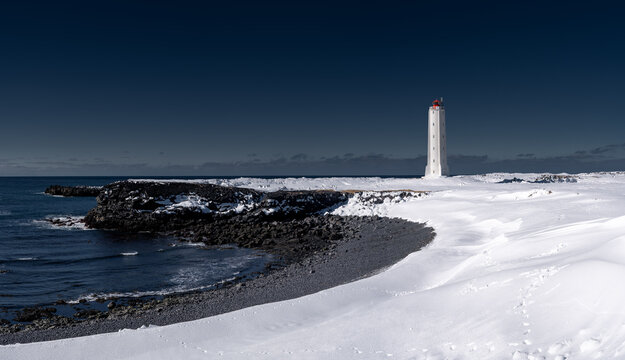 Winter Lighthouse on Snowy Coastline