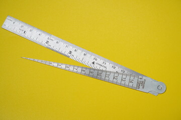 2 metal rulers isolated on yellow background