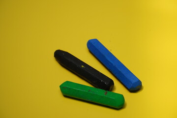3 crayons isolated on a yellow background. with Copyspace for text.