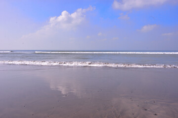 Expansive seascape of Cox's Bazar beach on the Bay of Bengal in Bangladesh, with a vast blue sky and gentle waves.