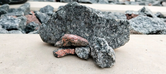 Assortment of Grey and Reddish Rocks on a Light Surface. Gray Stone with Rough Surface.