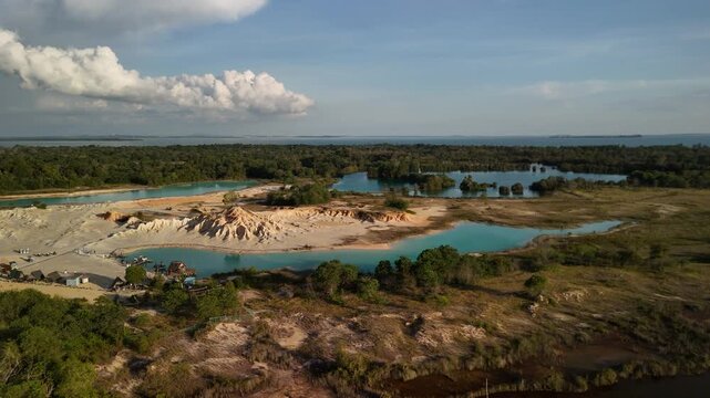 bintan islands blue lagoon also known as danau biru features striking turquoise waters surrounded by white sand hills creating a stunning contrast and serene tropical atmosphere