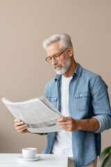 Senior man reading newspaper while enjoying coffee in cozy indoor setting