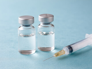 Vials and syringe for medical use on a blue background in a clinical setting