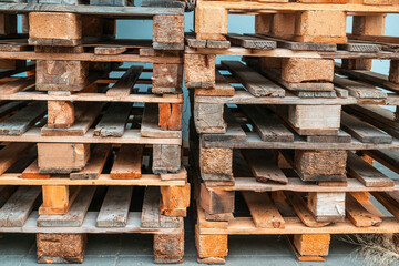 Stack of old used wooden euro pallets outdoors.