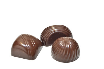 Chocolate candies with fillings of different shapes lie on a PNG background.
