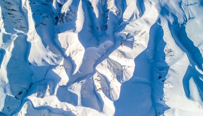 Aerial drone shot of snow-covered mountain patterns forming fractal geometry