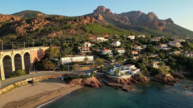 Aerial panoramic view of the Esterel Mountains near Saint Raphael, French Riviera, showing the Mediterranean Sea and luxury villas along the Cote dAzur coastline in the warm sunrise light