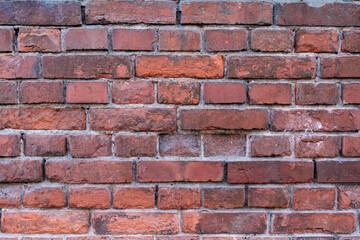 Close-up textured red brick wall with natural weathering.