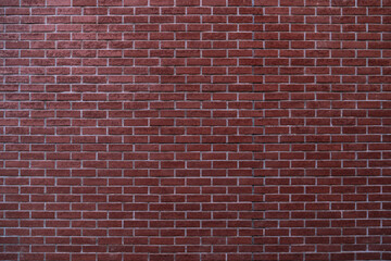 Wide view of a large red brick wall with uniform pattern.