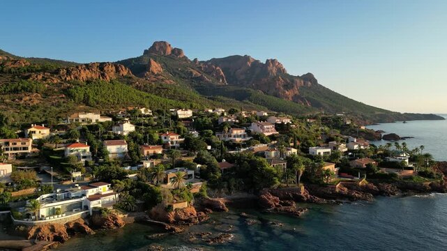 Aerial panoramic view of the Esterel Mountains near Saint Raphael, French Riviera, showing the Mediterranean Sea and luxury villas along the Cote dAzur coastline in the warm sunrise light