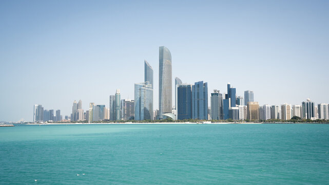 Coastal cityscape with high rise buildings and azure waters in foreground, United Arab Emirates