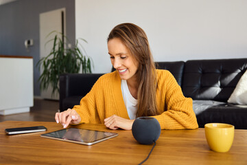 Woman setting  smart speaker using digital tablet