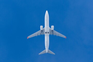 Passenger airplane viewed from below against clear blue sky