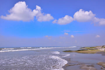 Fototapeta premium Expansive seascape of Cox's Bazar beach on the Bay of Bengal in Bangladesh, with a vast blue sky and gentle waves.