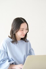 明るい部屋でパソコンを操作する日本人女性