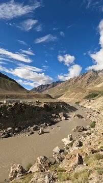 Peaceful morning view of the river flowing around Padum village in Zanskar Valley, north of India - calm water, mountains, and soft sunrise light.