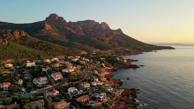 Aerial panoramic view of the Esterel Mountains near Saint Raphael, French Riviera, showing the Mediterranean Sea and luxury villas along the Cote dAzur coastline in the warm sunrise light