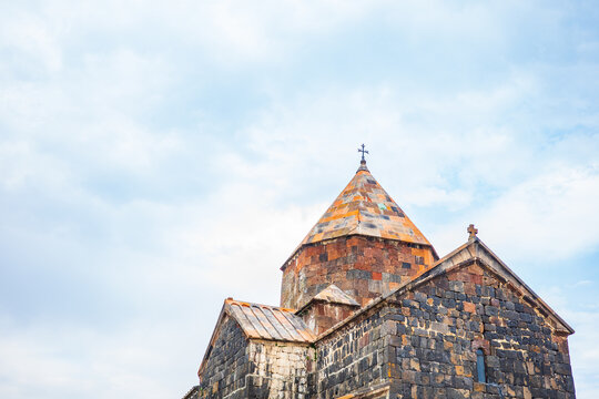 Sevanavank Monastery, an ancient Armenian church built from volcanic tuff and basalt stones, stands proudly under a bright blue sky. The historic monastery symbolizes Armenia&rsquo;s deep spiritual roots