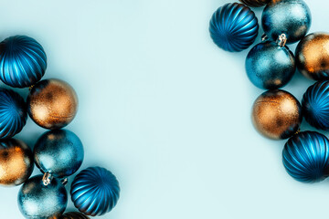 Blue and gold christmas baubles on light blue background with copy space. Top view, flat lay, copy space