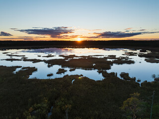 Aerial drone view of a beautiful sunset over Seli Lake in Seli bog, Estonia, with stunning water reflections.