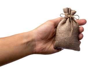 Human hand holding small burlap sack tied with string isolated on a transparent background