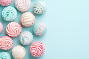 Fototapeta premium Pastel macarons and cupcakes on soft pastel background, sweet minimal dessert composition.