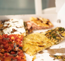 Gourmet Roman-style pizza alla pala with speck, cherry tomatoes and basil, and artisan focaccia