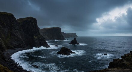 Obraz premium Cold weather, heavy cloudy day over rugged coastline with dark sea and rock formations. Concept of power and immensity of nature.