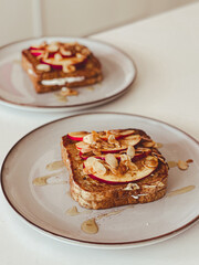 Two plates of toast with apples and almonds on top