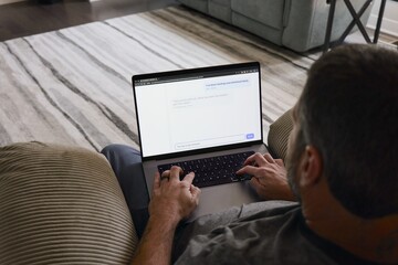 Middle Aged Man in Tan Recliner Texting AI Chatbot